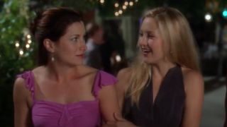 Kathryn Hahn and Kate Hudson in How to Lose a Guy in 10 Days walking arm in arm on the street walking and talking.