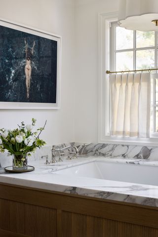 a cafe curtain over a bathtub in a modern white bathroom