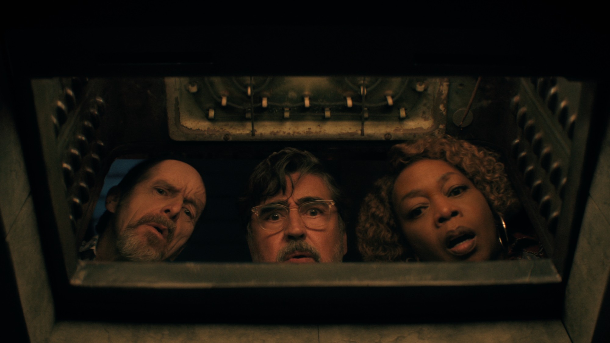 Denis O'Hare, Alfred Molina and Alfre Woodward stare into the camera from above, seeming to look into a dark, terrifying location