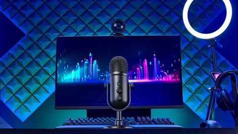The Razer Seiren V2 Pro sits on a desk with other Razer products.