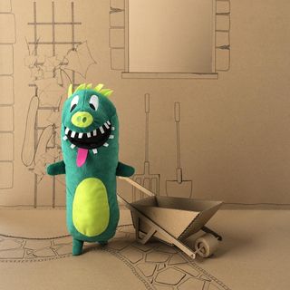 green sagoskatt cuddly toy with cardboard castle
