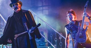King Diamond and guitarist Andy La Rocque: The King is in his traditional stagewear, undertaker's hat, crossbones mic stand, totally morbid corpsepaint. La Rocque frets a chord on his signature ESP.
