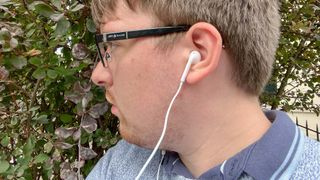 A man wearing the Apple EarPods