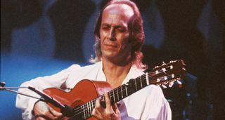With his eyes closed, Paco de Lucia frets a chord on a nylon-string guitar in this live shot from a 1991 performance.