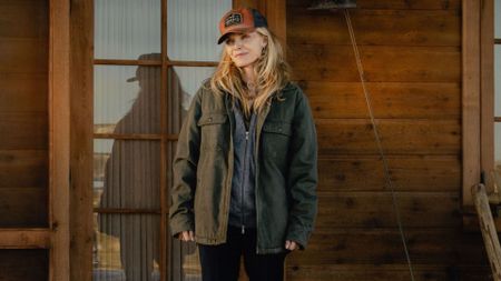 Michelle Pfeiffer looks at something across her cabin porch