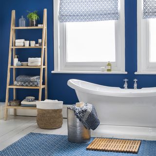 bathroom with white bathtub and wooden rack