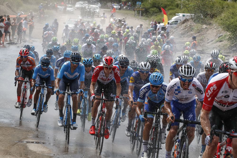 The peloton rides through water on the road near the end of stage 4 in San Juan