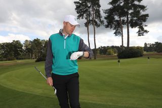 A golfer checking his Apple Watch on course