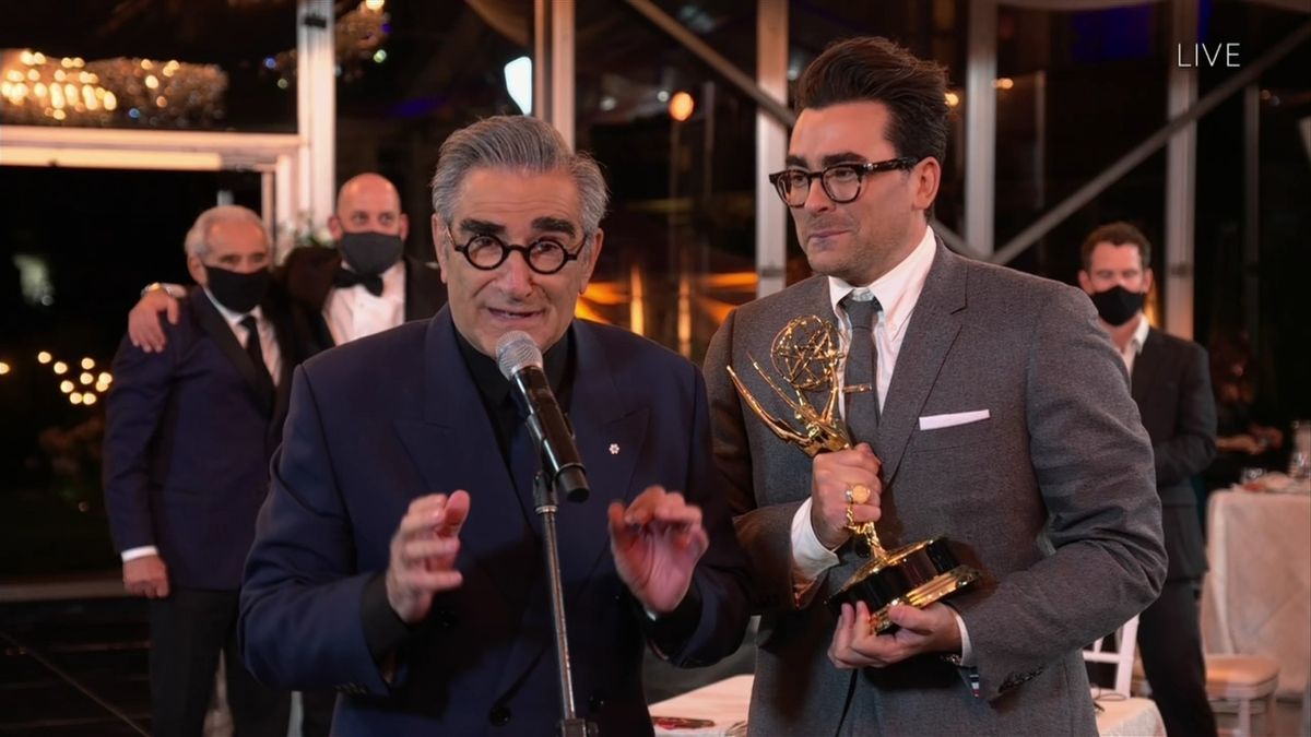 Dan Levy looks on as his father Eugene Levy delivers his part of their acceptance speech at the 72nd Emmys.