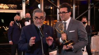 Dan Levy looks on as his father Eugene Levy delivers his part of their acceptance speech at the 72nd Emmys.