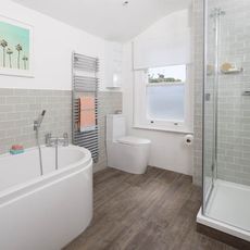 bathroom with wooden flooring and white bath tub