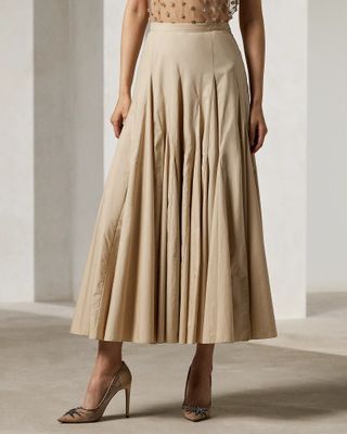 Model is wearing a beige pleated A-line midi skirt