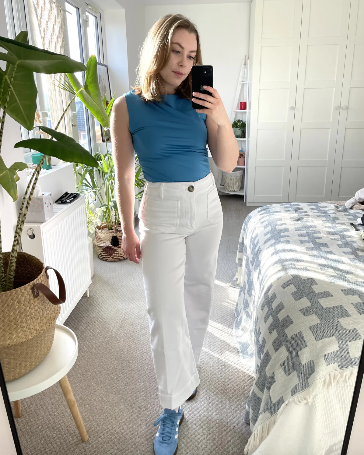 Shopping editor Florrie Alexander wears a blue top, white jeans and blue trainers in a recent image taken from her Instagram
