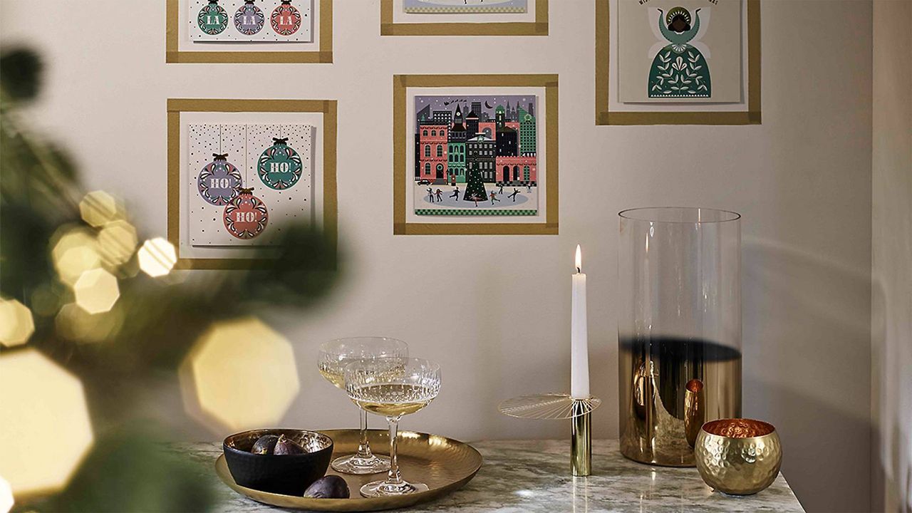 A gallery wall made up of framed Christmas cards using gold tape