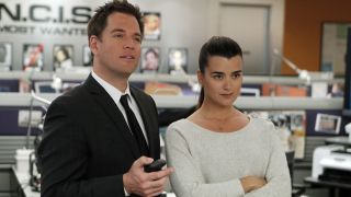 Michael Weatherly and Cote de Pablo looking at display screen on NCIS