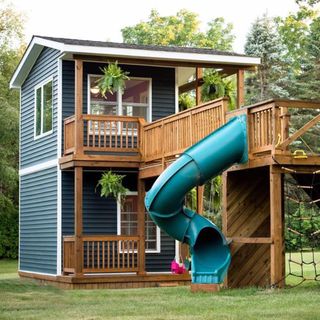 play house in the garden with wooden bridge and plants