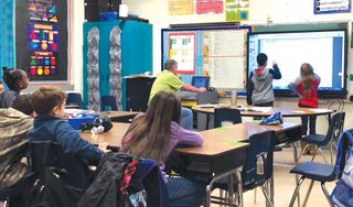 Two Neshoba Central Elementary School students work together at an interactive panel, critiquing each other’s work.