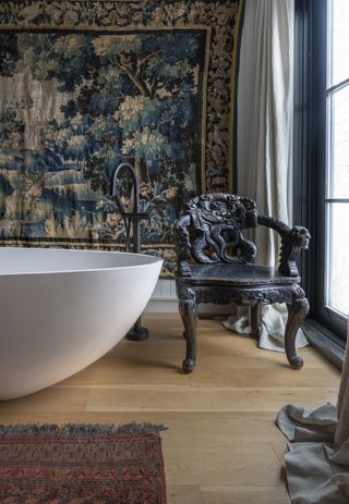 A master bathroom with a large tub and two rugs - one on the floor, one on the wall