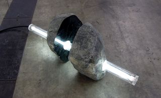 Sculpture of rock with light rod through