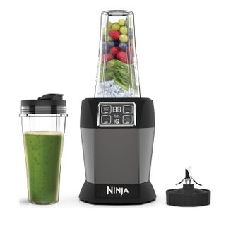 Ninja Blender with Auto-IQ BN495UK with ice, spinach and fruit in the main cup and a blended green drink in the travel cup