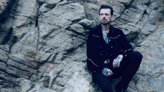 Ricky Warwick posing for a photograph on rocks