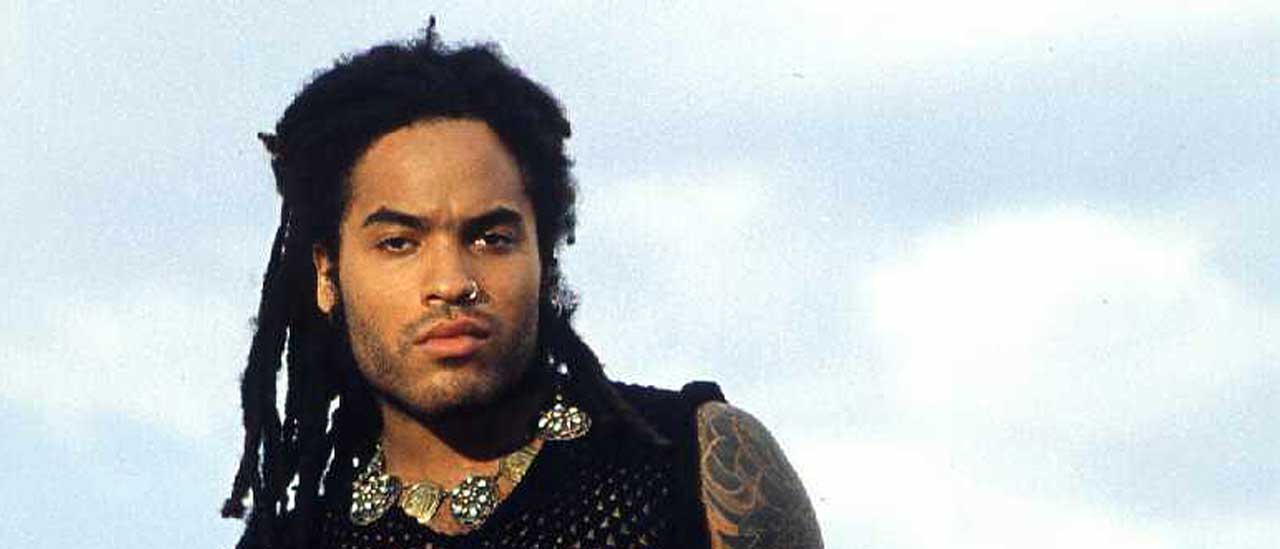 Lenny Kravitz on a beach with clouds behind him