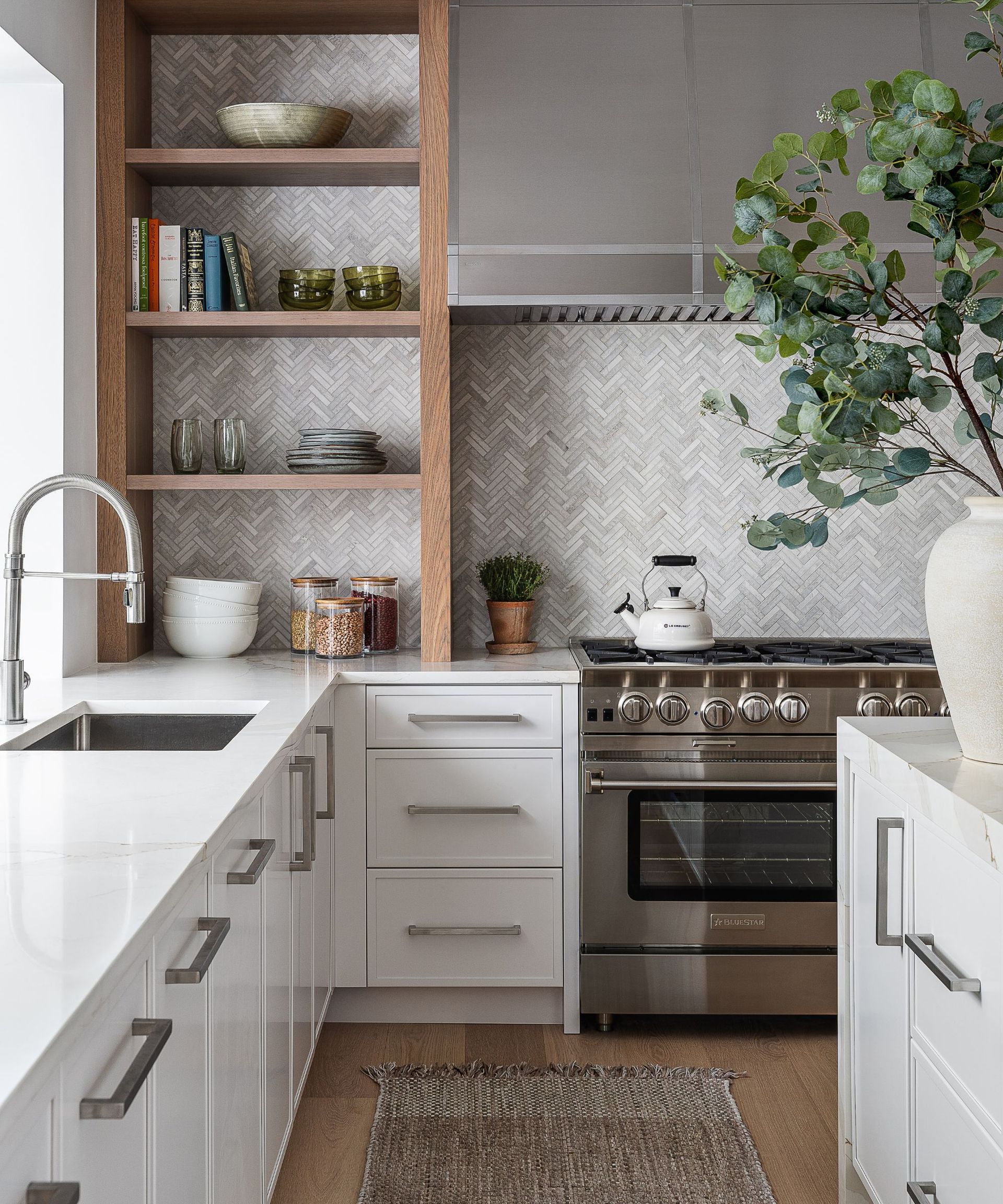 Chrome range cooker in a white kitchen, matched with chrome cabinet hardware