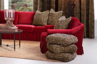 a red sofa with leopard print pillows and ottoman