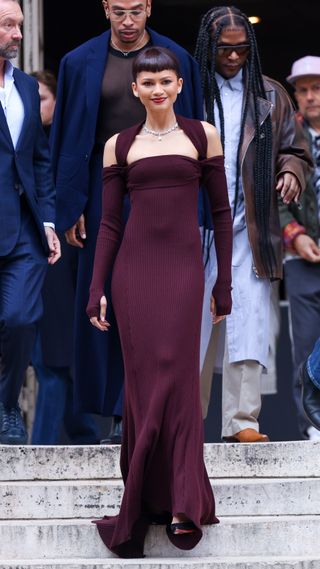 Zendaya attending the Fendi Couture Show wearing an eggplant-colored long sleeve gown with shoulder cutouts
