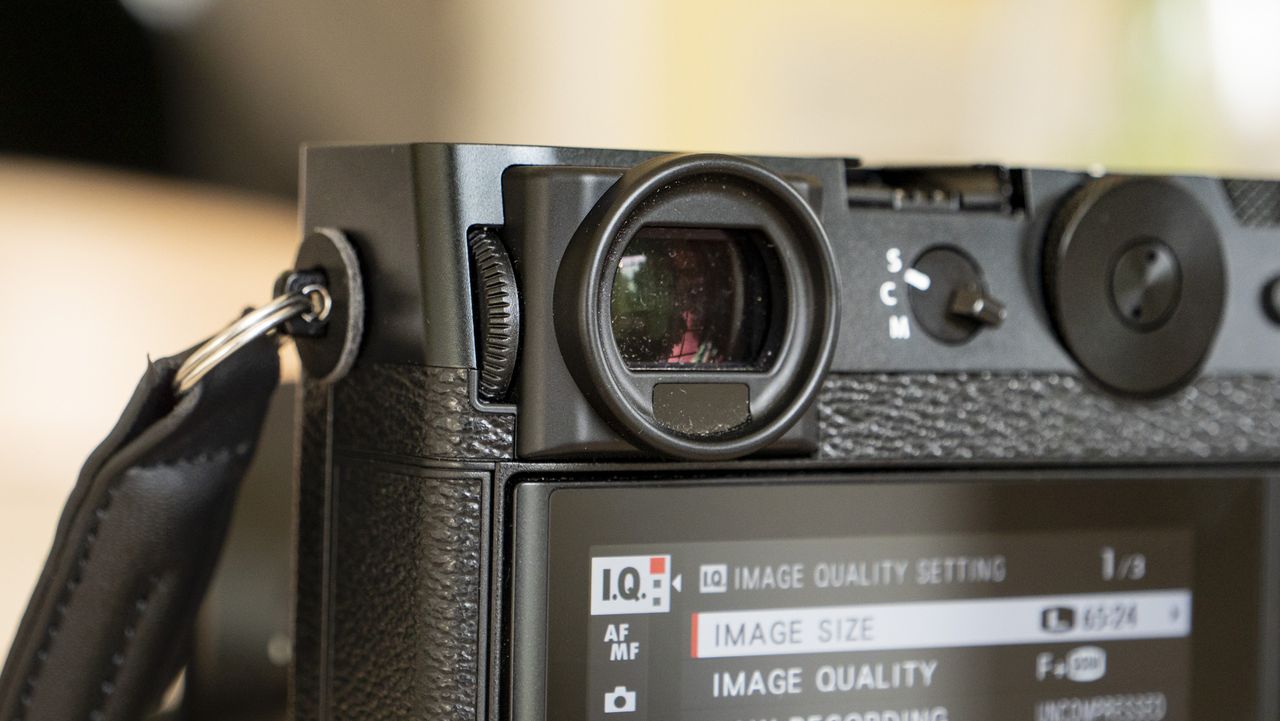 All-black Fujifilm GFX100RF rangefinder-style camera on a wooden table