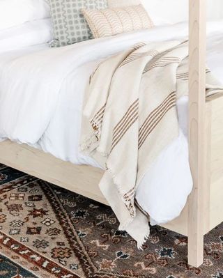 cream throw blanket with brown stripes on white bedding