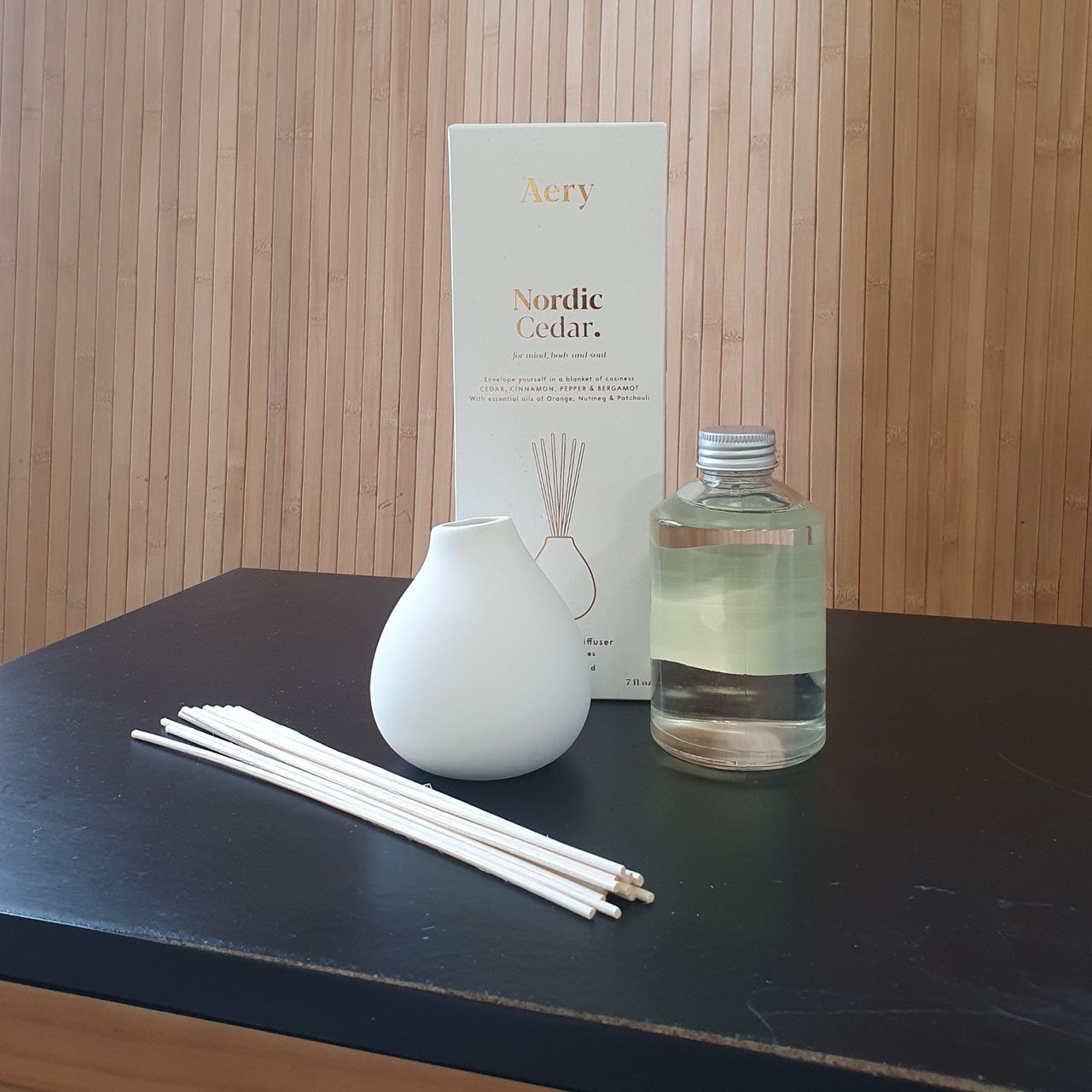 The contents of the Nordic Cedar reed diffuser box by Aery Living