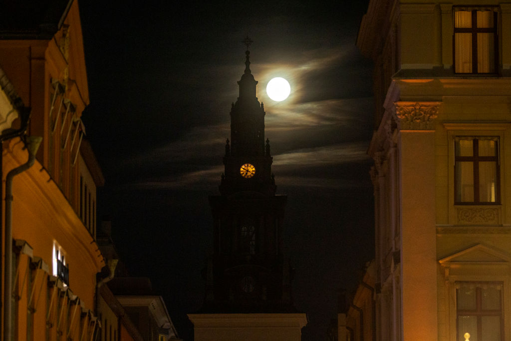 A yellow sphere behind a dark bell tower