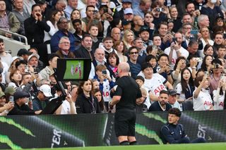 Referee Simon Hooper looks at the VAR monitor before giving a red card to Curtis Jones of Liverpool during the Premier League match between Tottenham Hotspur and Liverpool FC at Tottenham Hotspur Stadium on September 30, 2023 in London, England. (Photo by Matthew Ashton - AMA/Getty Images)