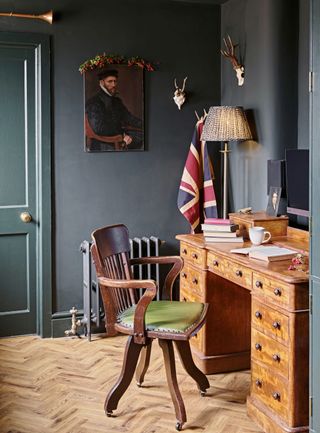 traditional-style study with dark green walls and vintage furniture