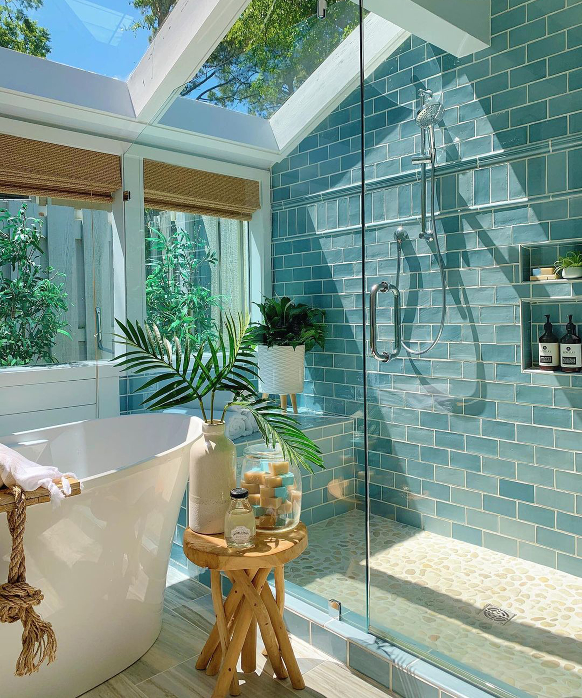 A small bathroom idea with teal blue green bathroom tiles in shower cubicle with shower cubby, freestanding bath and rooflight windows