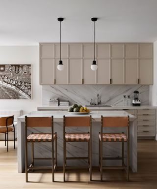 Marble kitchen island, beige kitchen cabinets, brown chairs