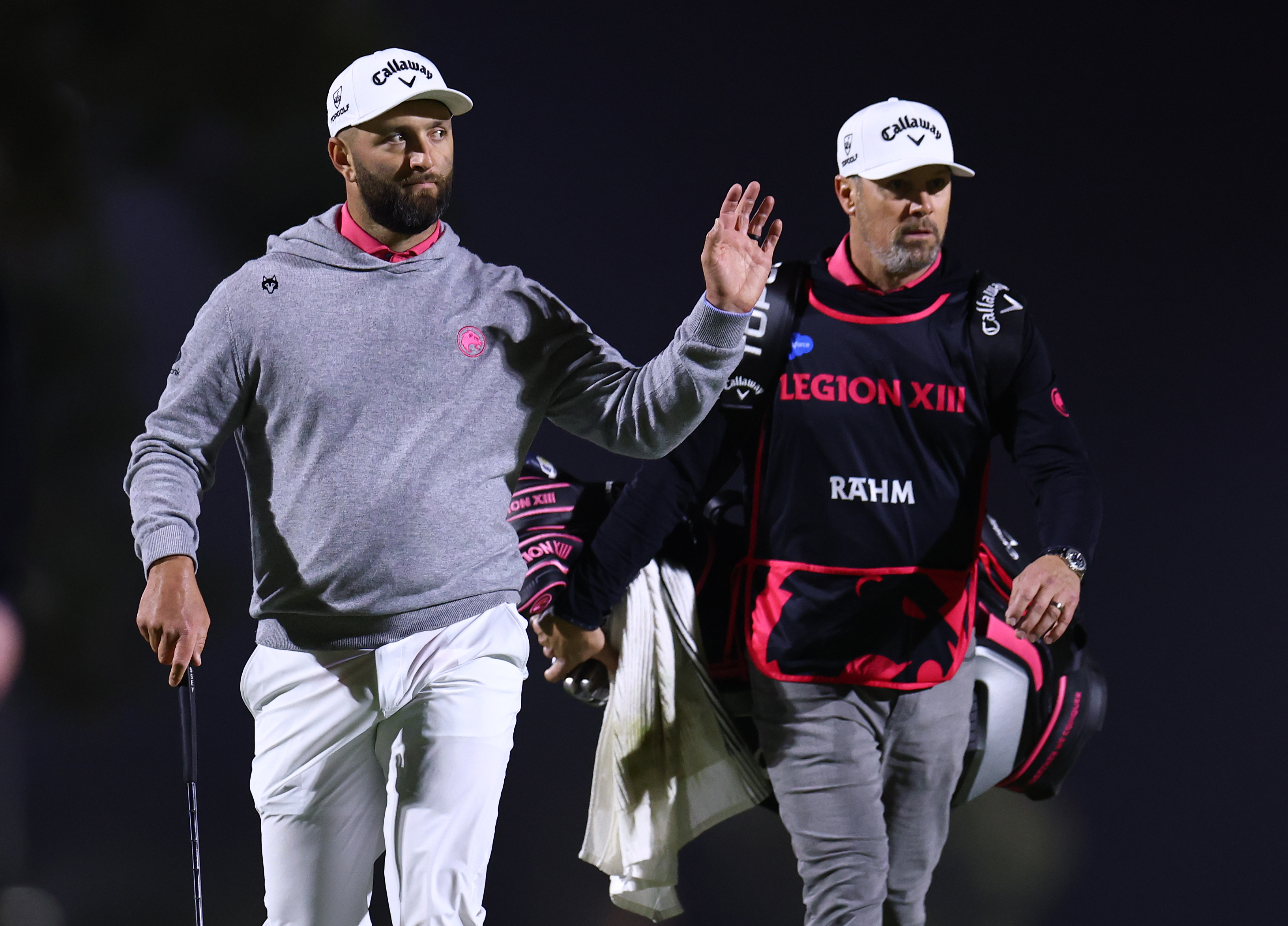 Jon Rahm and his caddie walk onto the 12th green on day three of LIV Golf Riyadh