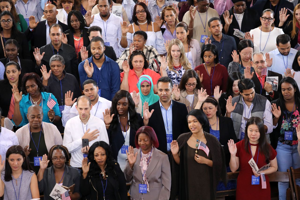 Immigrants take the oath of citizenship to the United States in the Great Hall of Ellis Island.