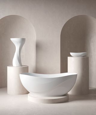 curved bath displayed on stone pedestal next to sink