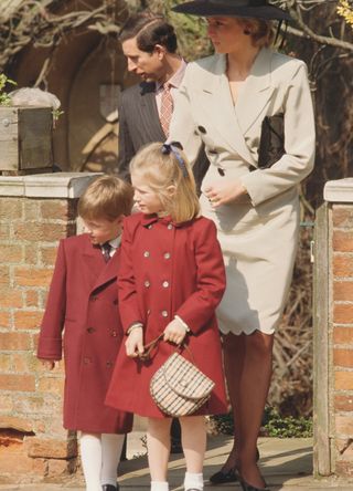 A young Prince William and Zara Phillips in matching red coats