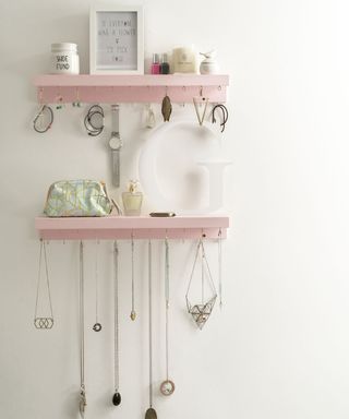 white wall with pink shelf and jewellery storage