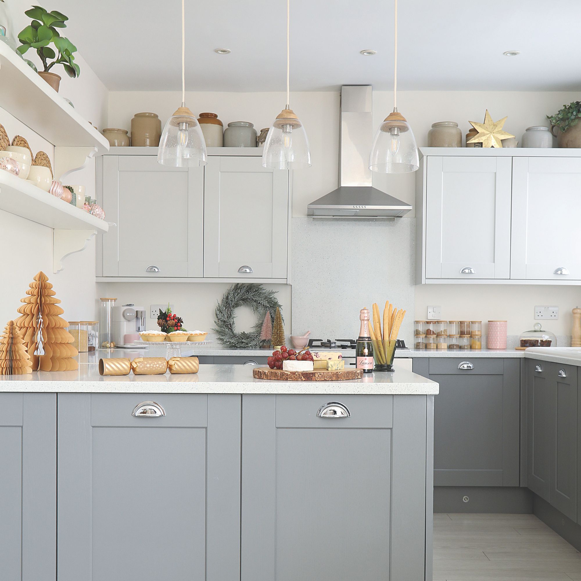 White painted kitchen with grey cabinets and christmas decorations and food on the worktops