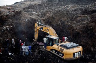 Rescue workers watch as excavators dig through garbage in search of missing people following the collapse of a mound of trash on an informal settlement at the Koshe garbage dump in Ethiopia's capital Addis Ababa, March 13, 2017. 