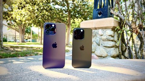 iPhone 14 Pro Max Deep Purple and iPhone 14 Pro Space Black next to each other on the ground.