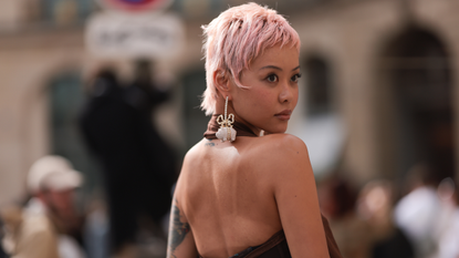 woman with cropped pink hair looking over her shoulder - best shampoo for coloured hair 1711983460