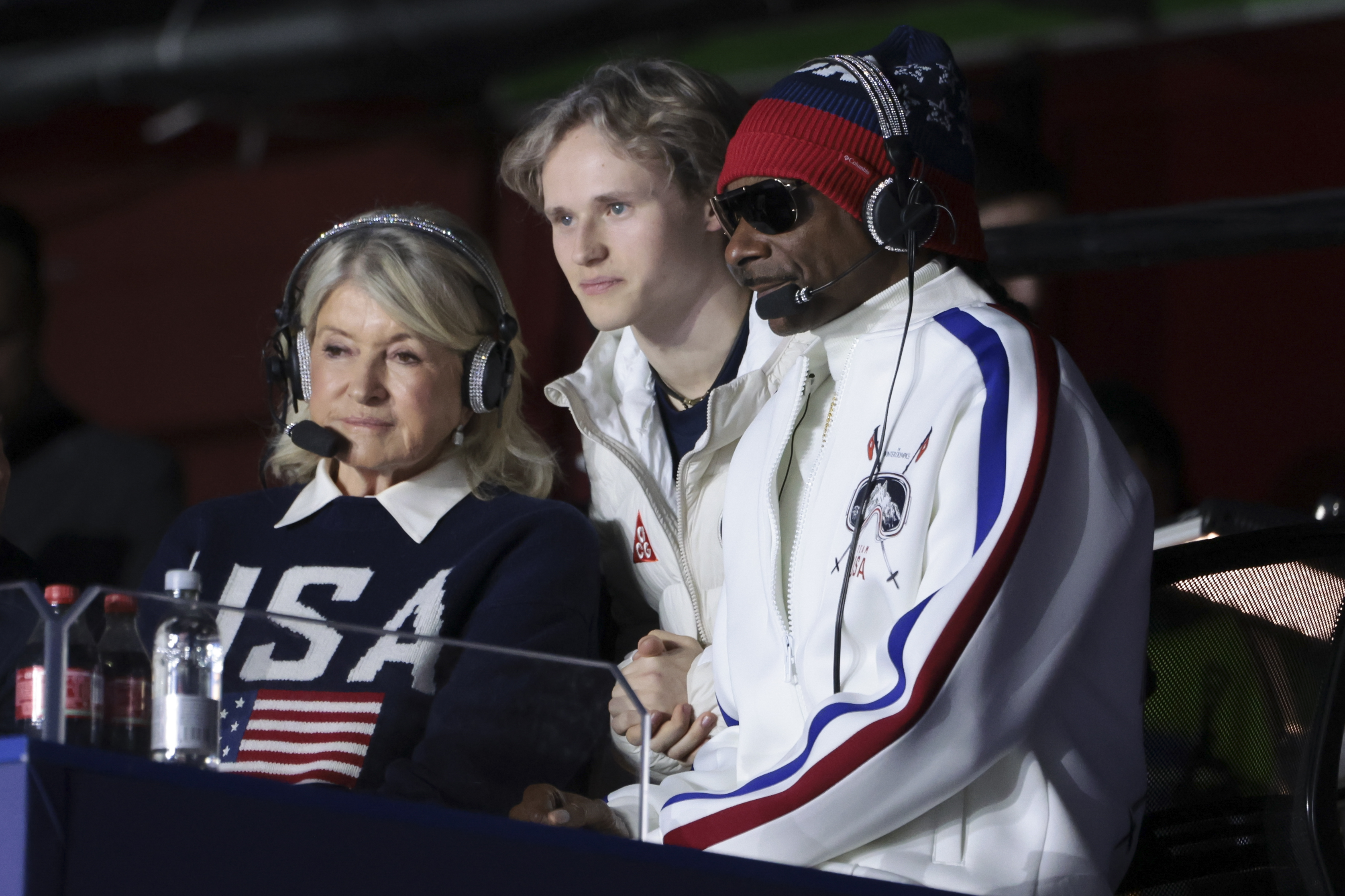 Snoop Dogg, martha Stewart and Ilia Malinin wearing USA Olympics clothing and headphones