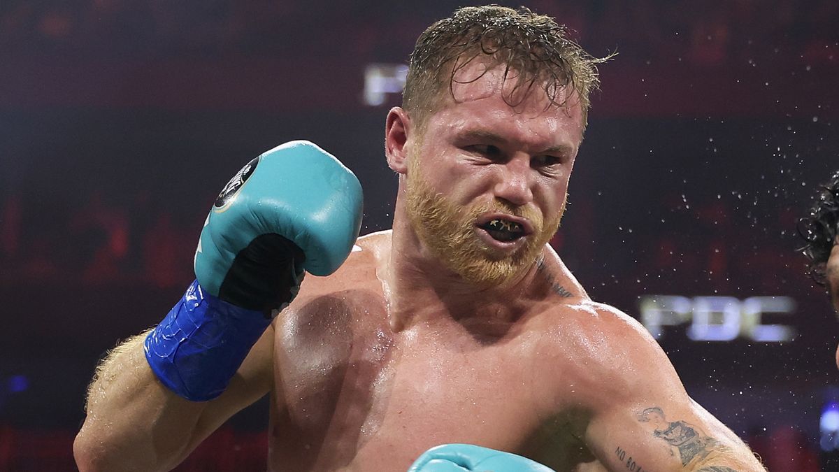 Saul &#039;Canelo&#039; Alvarez throwing a punch wearing sky blue boxing gloves.