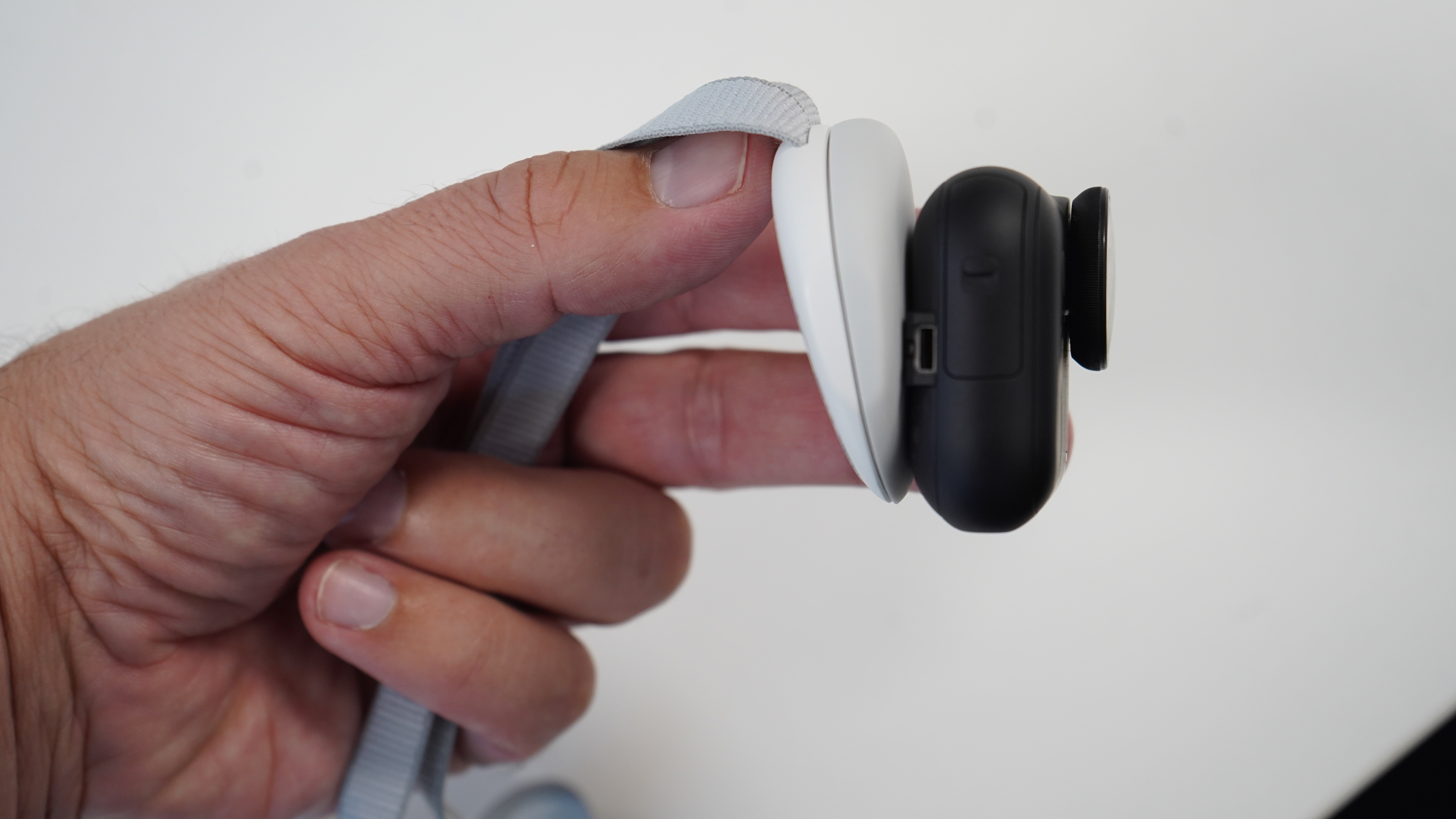 Insta360 GO Ultra in my hand with the neck pendant turned to wedge shape