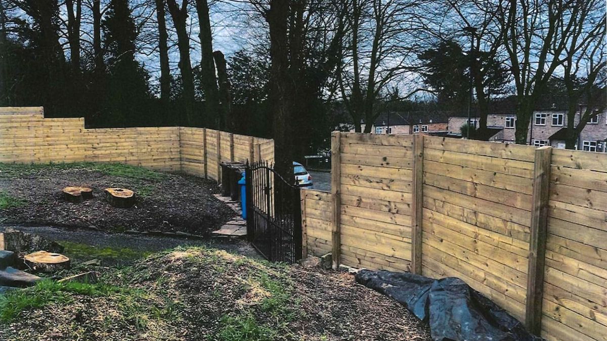 A wooden fence on a sloped front garden